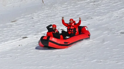 Karla kaplı dağdan donmuş gölete botla kaydılar
