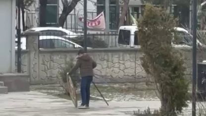 Rüzgârın devirdiği polis çelengini genç yerine koydu